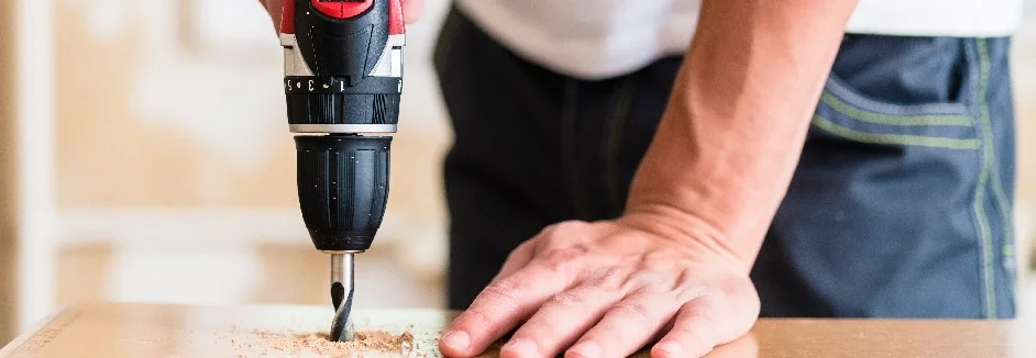 Person bohrt mit Akkuschrauber in Holz